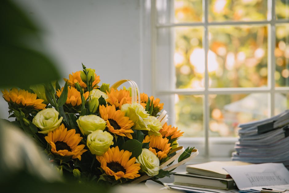 A vibrant bouquet of fresh sunflowers with bright yellow petals and dark centers, complemented by creamy white eustoma flowers and green foliage, arranged in a natural, loose style. The bouquet is pla